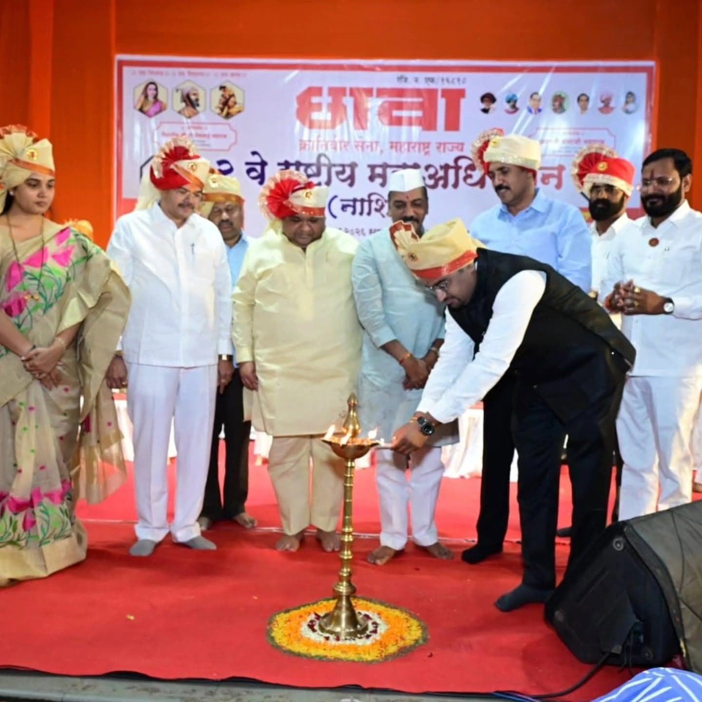 Dr. Gaurav Deore of Shishu Child Care Clinic lighting the lamp at a community event in Nashik